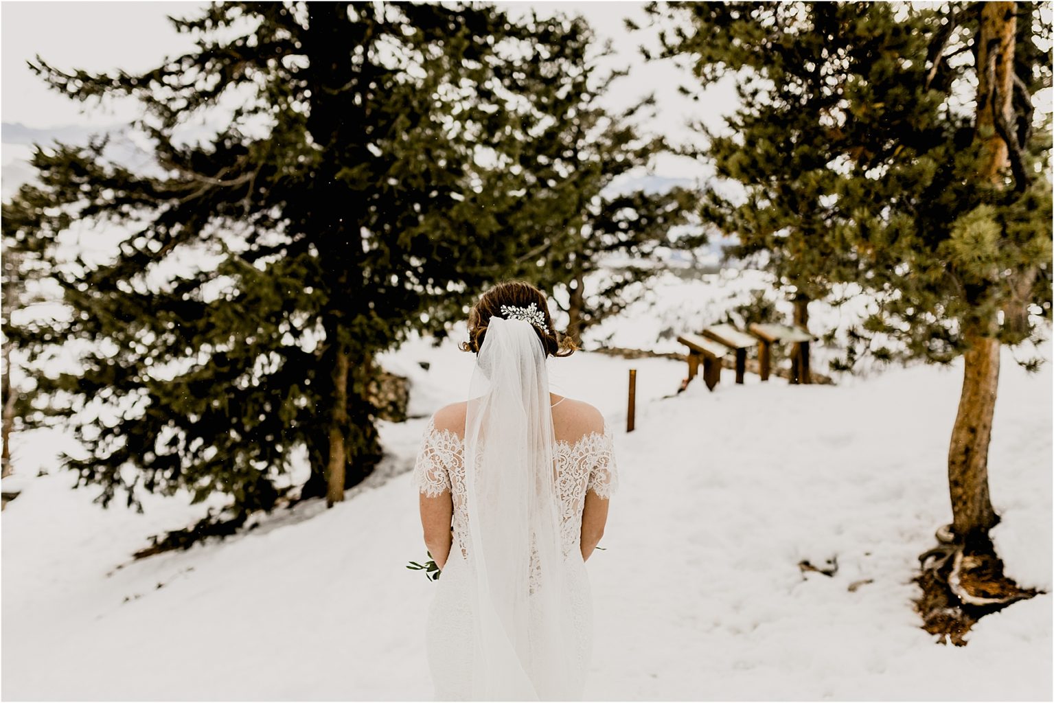 beautiful bride walking through the snow for her snowy colorado elopement at sapphire point in breckenridge colorado