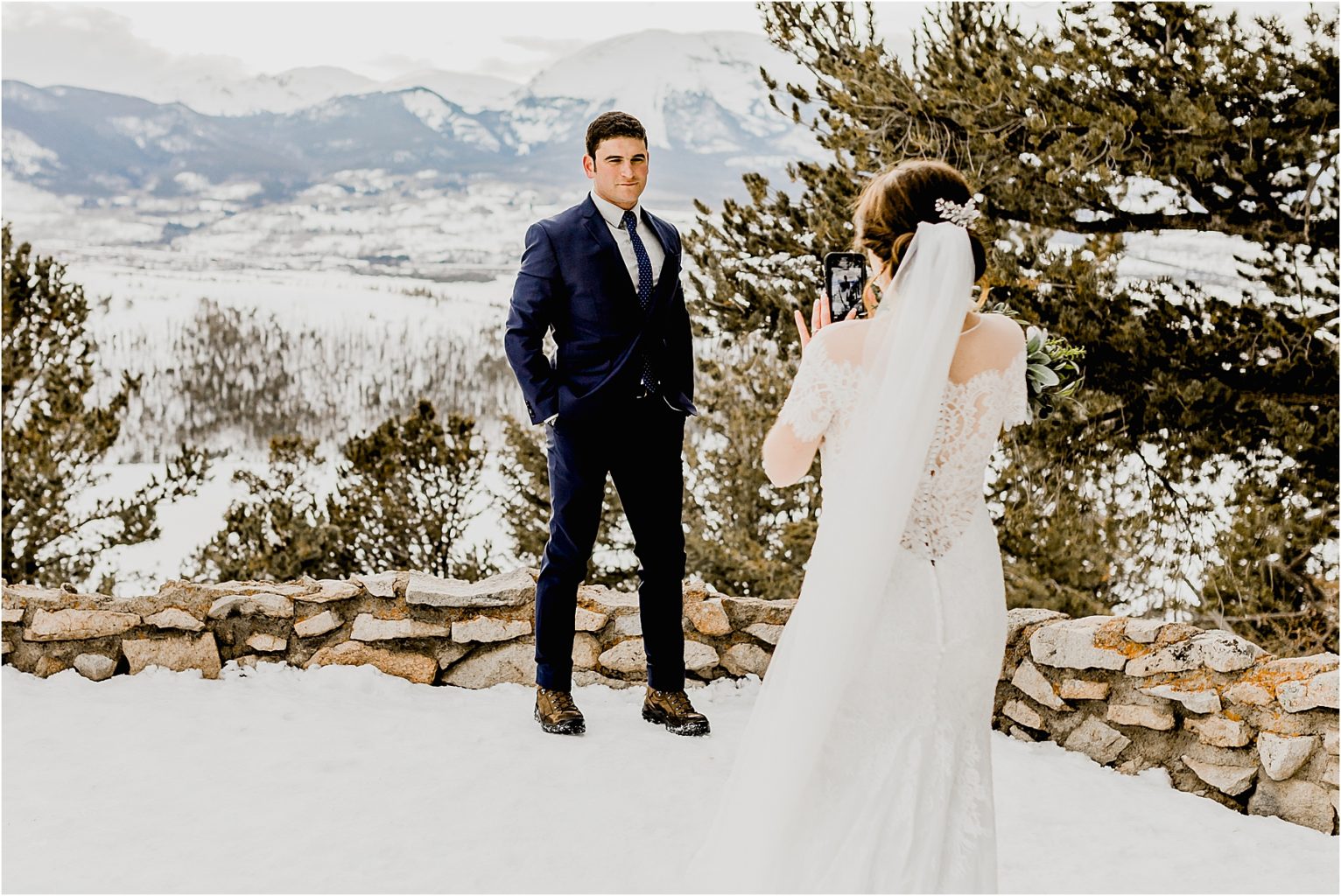 bride taking photo of groom in colorado