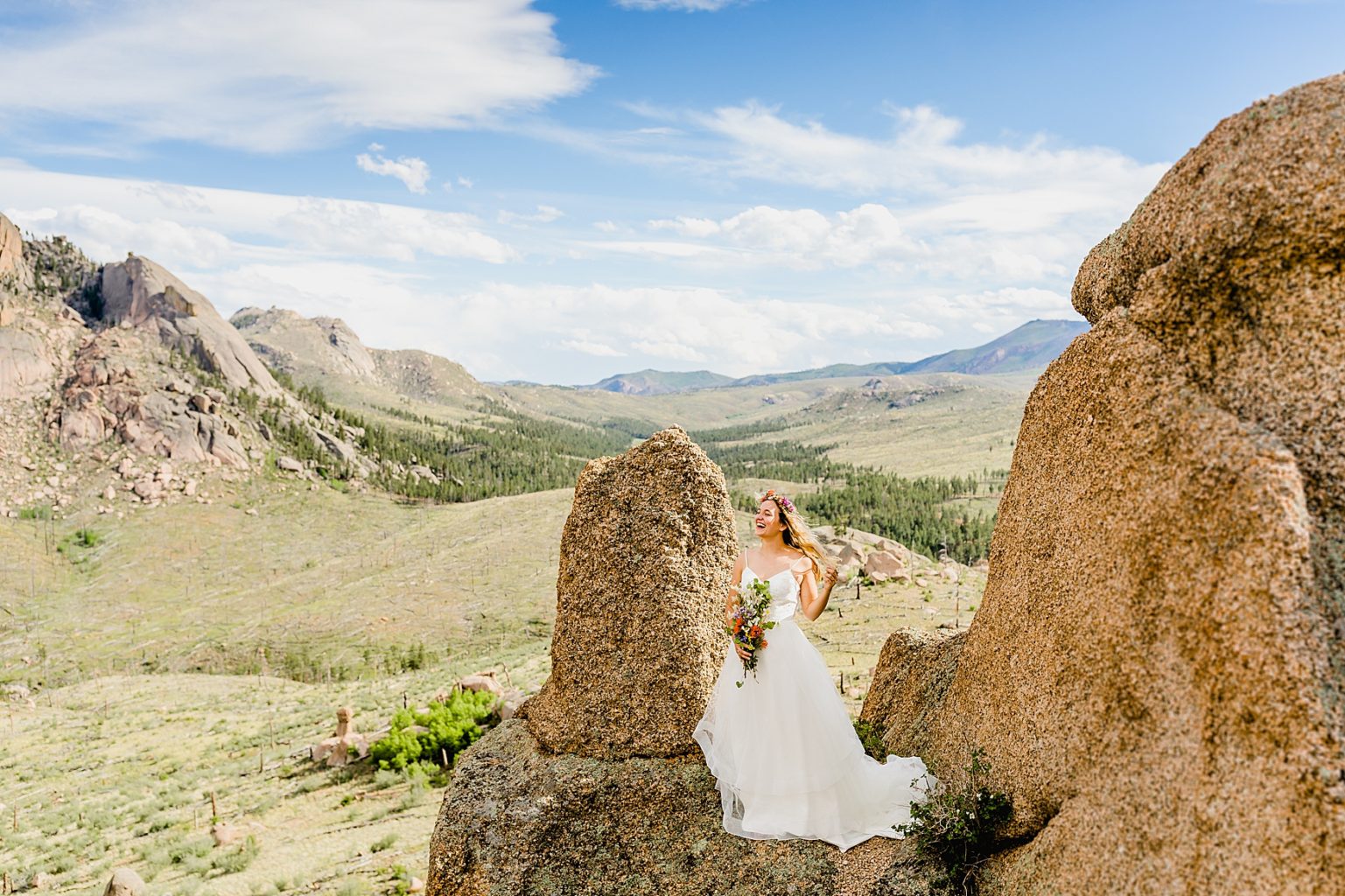 bride standing on rock for her Colorado elopement with beautiful mountain background