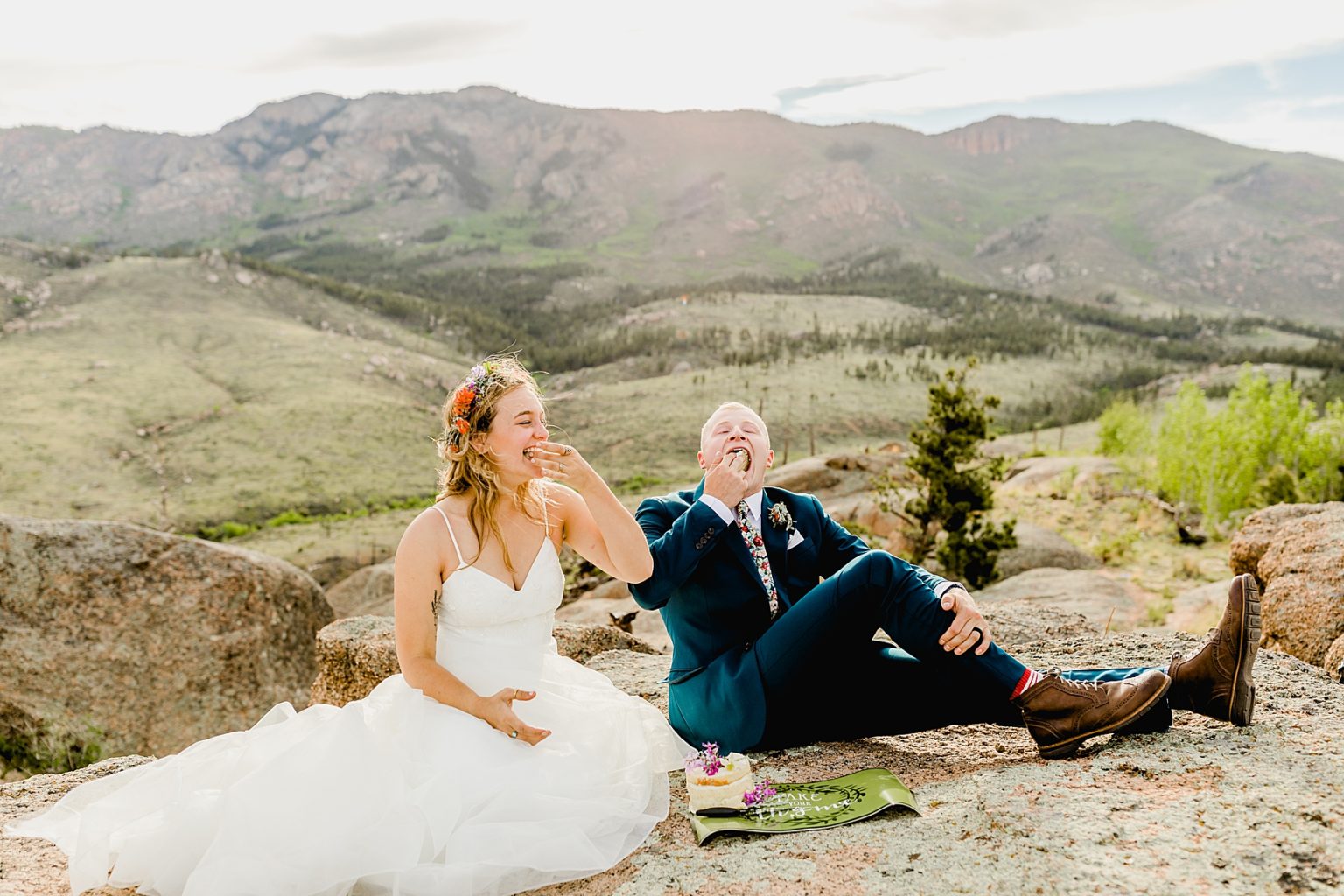 bride and groom eating cake for their Colorado elopement in the outdoors