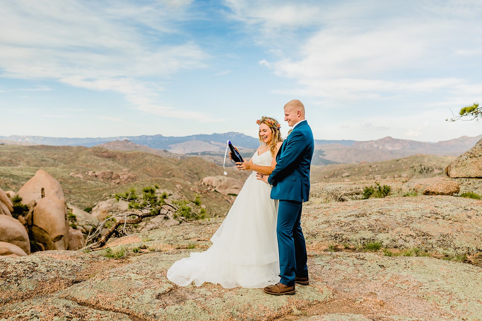 bride and groom popping champagne for their Colorado elopement in mountains