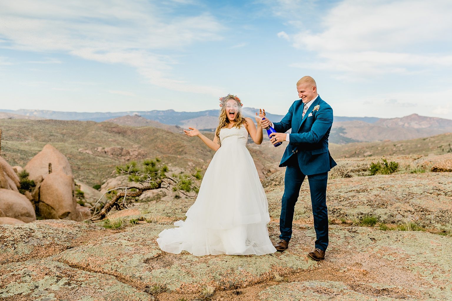 bride and groom popping champagne for their Colorado elopement in mountains