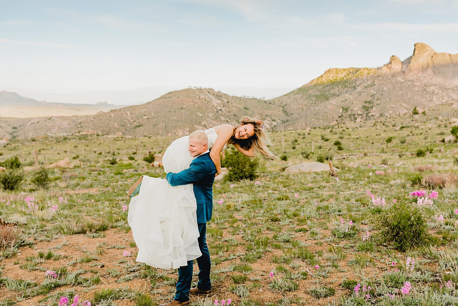 bride and groom in Colorado in the mountains surrounded by wildflowers for mountain elopement