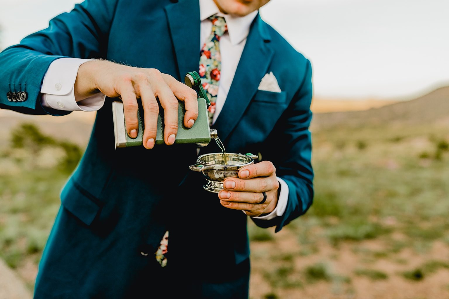 groom pouring whiskey in flask