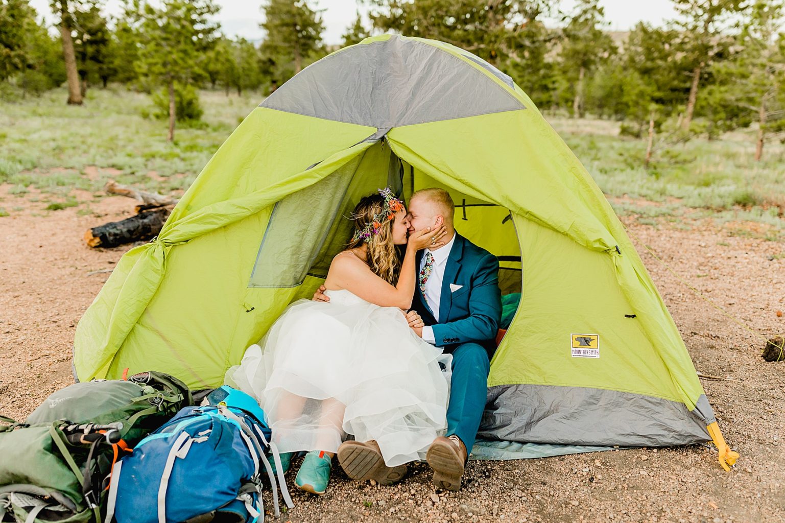 colorado bride and groom sitting in tent to camp after elopement