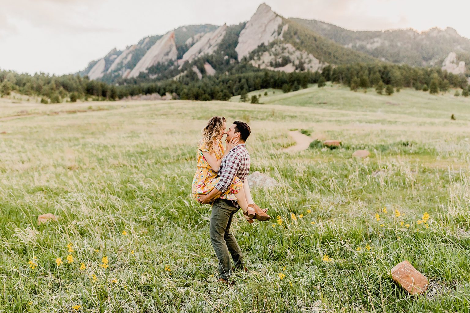 adventurous couple at sunset in boulder colorado chautauqua park for summer engagement photos among the beautiful wildflowers