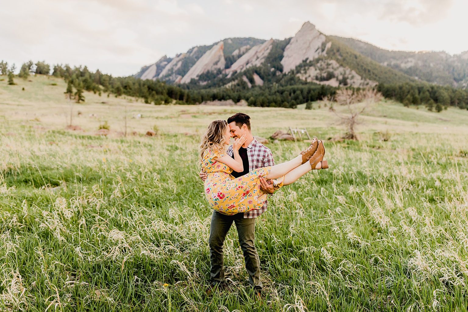 adventurous couple together at chautauqua park in boulder colorado for their mountain engagement photos including beautiful green scenery and summer wildflowers