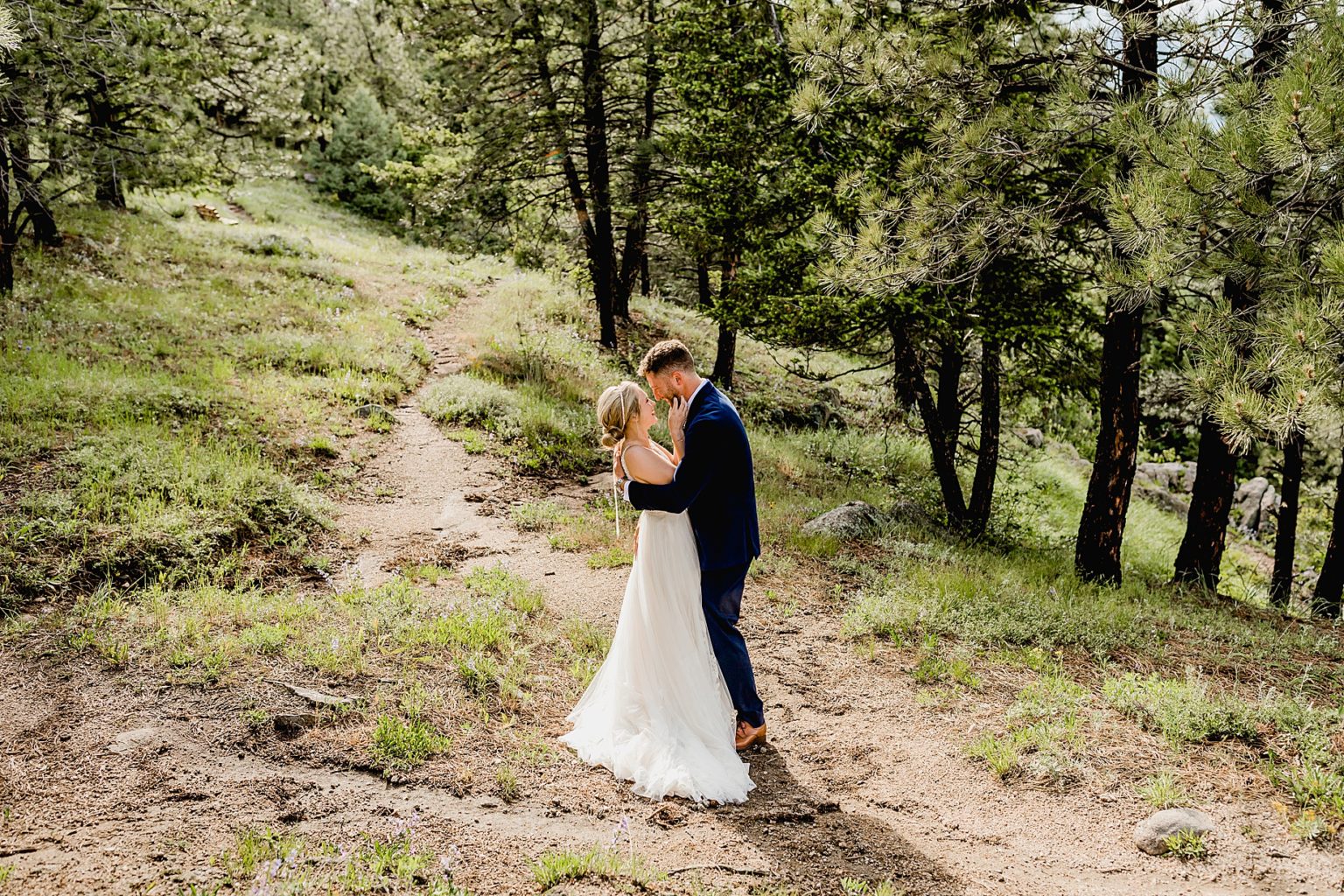 bride and groom embrace each other after their first look on wedding day in the trees of colorado