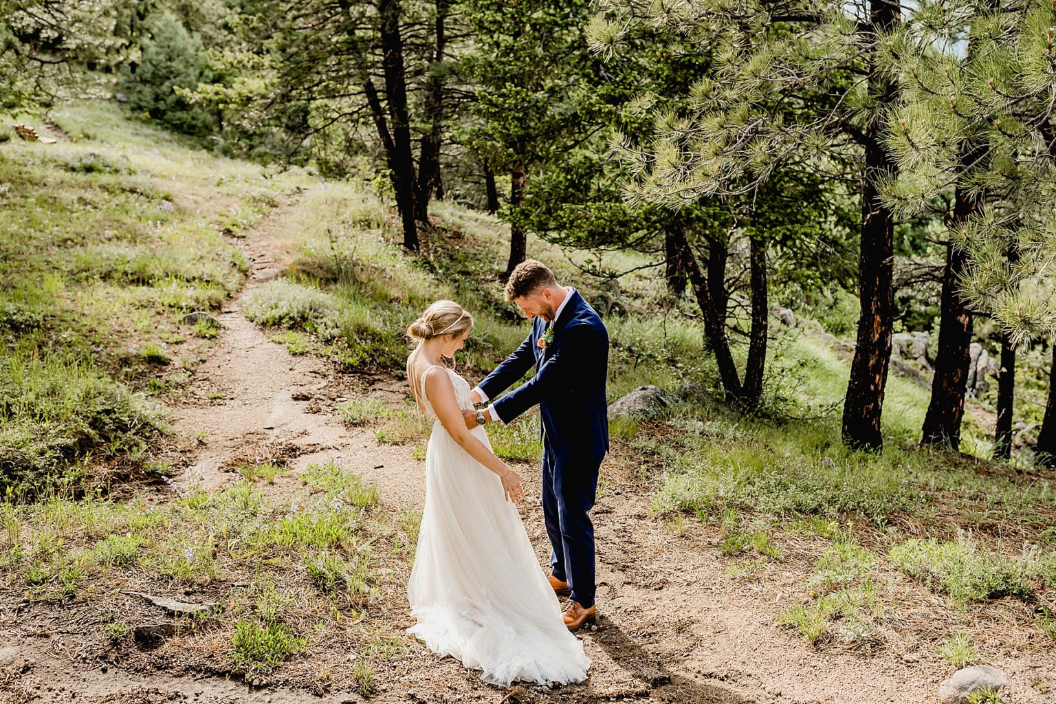 bride and groom embrace each other after their first look on wedding day in the trees of colorado
