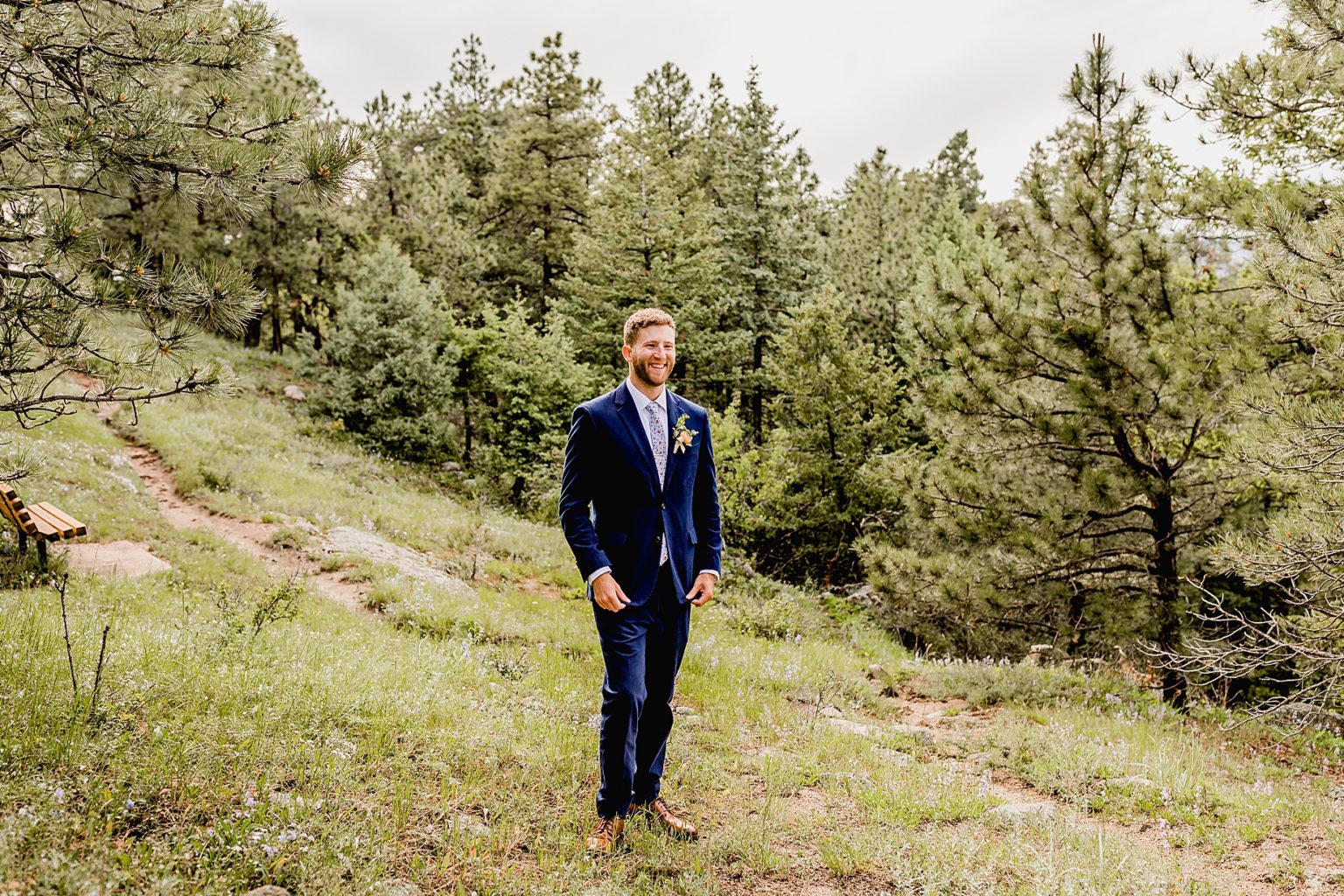 groom stares off into the colorado mountains on his wedding day