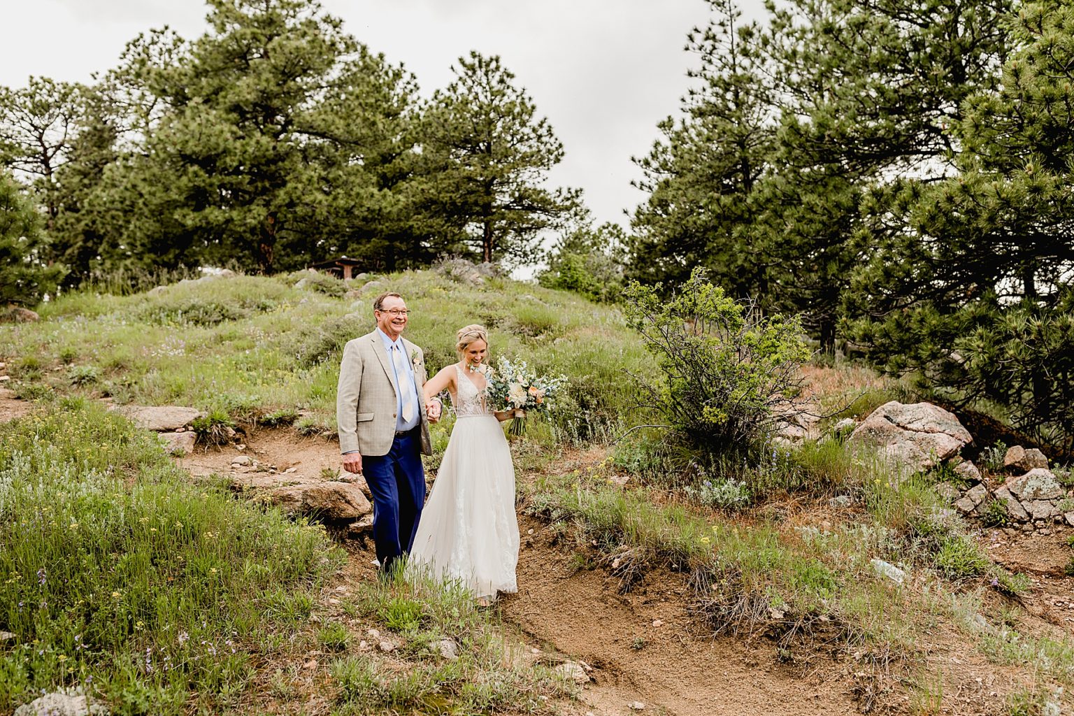 bride and her dad are walking on a path to colorado ceremony