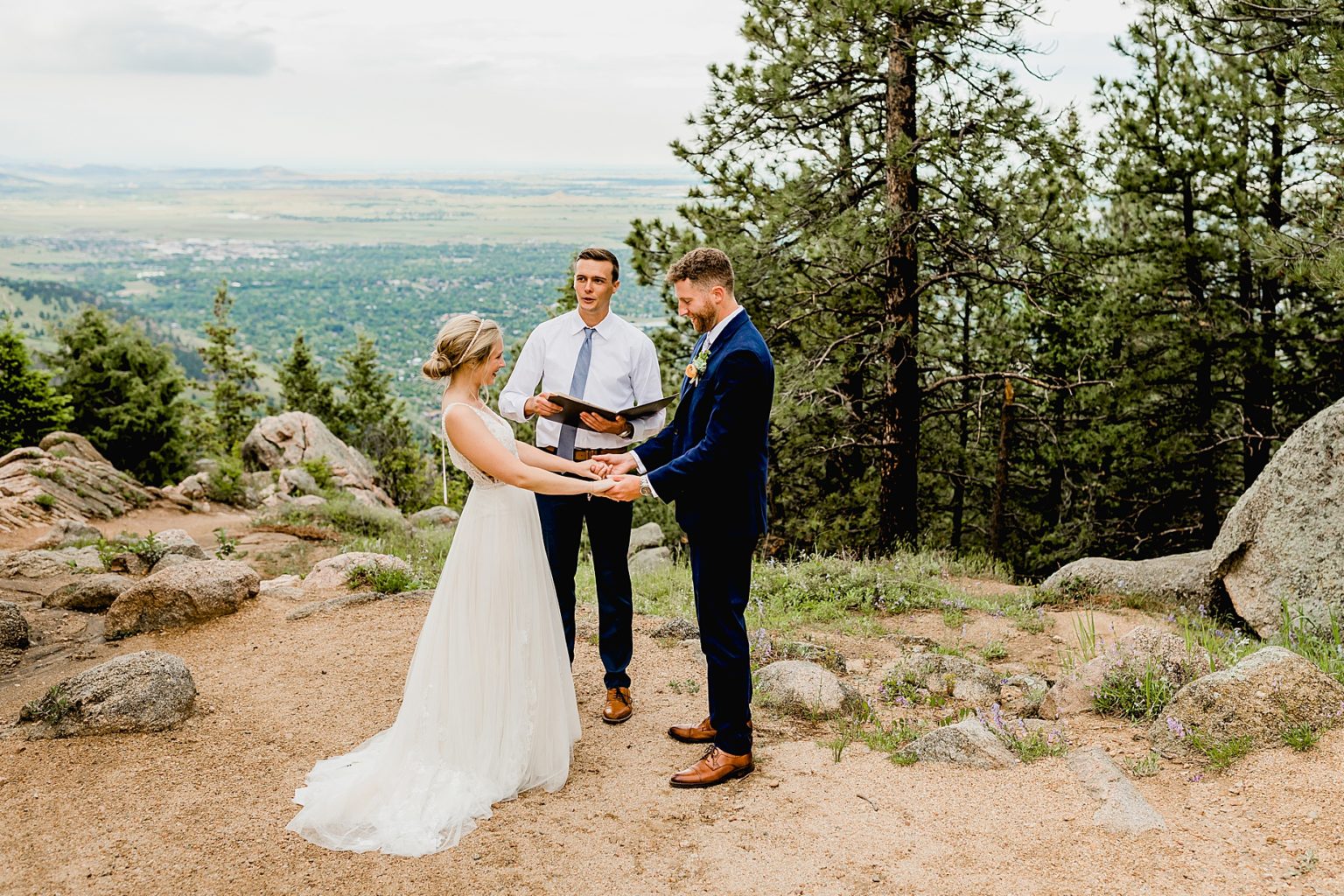bride and groom hold hands during their elopement ceremony in boulder