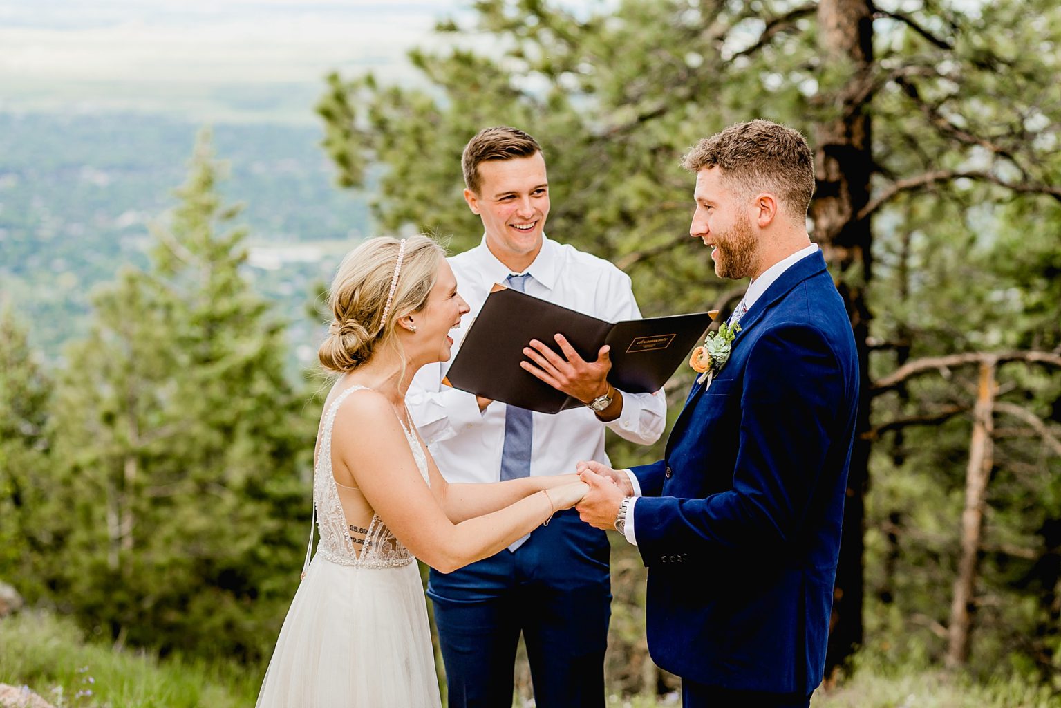 bride and groom hold hands during their elopement ceremony in boulder