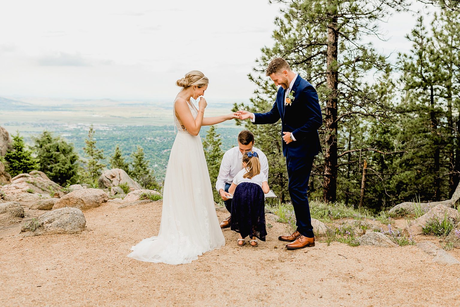 bride and groom exchange rings during their intimate ceremony with views of the boulder mountains in colorado