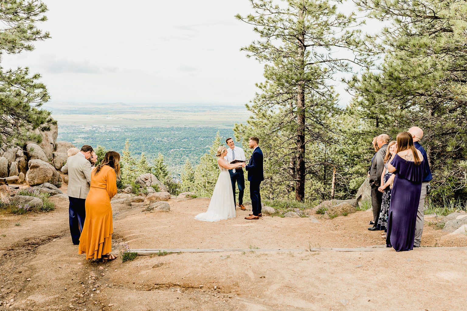 bride and groom have their intimate wedding ceremony with views of the boulder trees and mountains