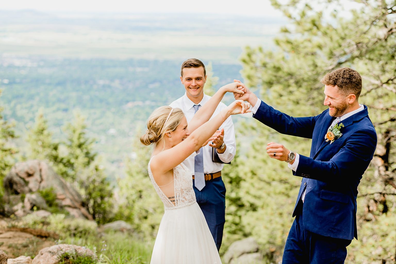 bride and groom celebrate being officially married by throwing hands in the air