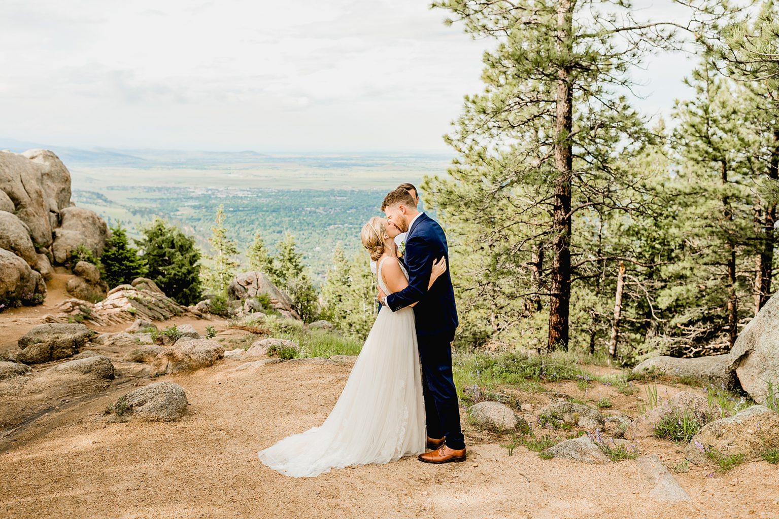 bride and groom share first kiss during ceremony with beautiful colorado mountain views