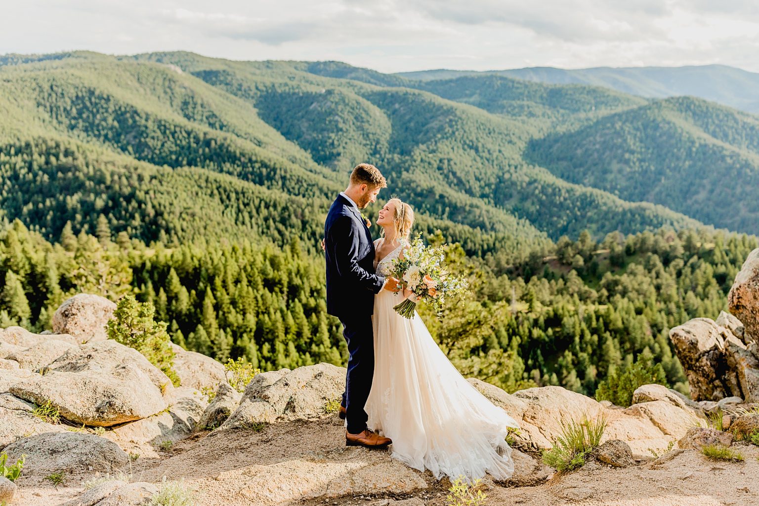 couple embracing for their elopement with stunning mountain views of colorado