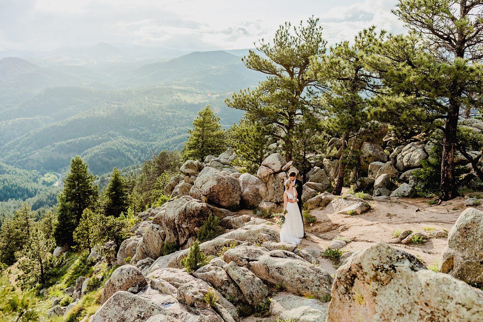 couple embracing for their elopememt with gorgeous mountain views of colorado