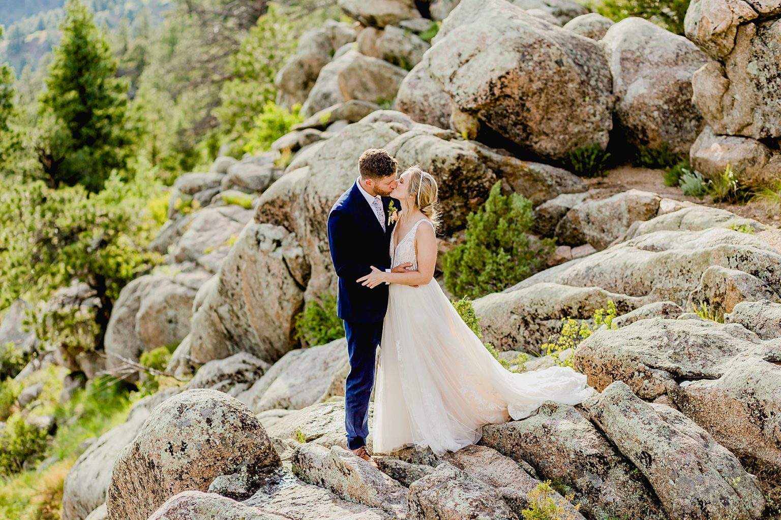 bride and groom kiss with beautiful rock formations behind them showing off boulder colorado