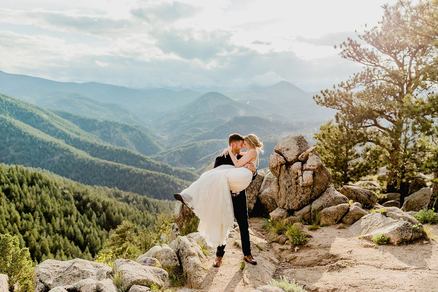 groom picks up bride with stunning Rocky Mountain colorado background