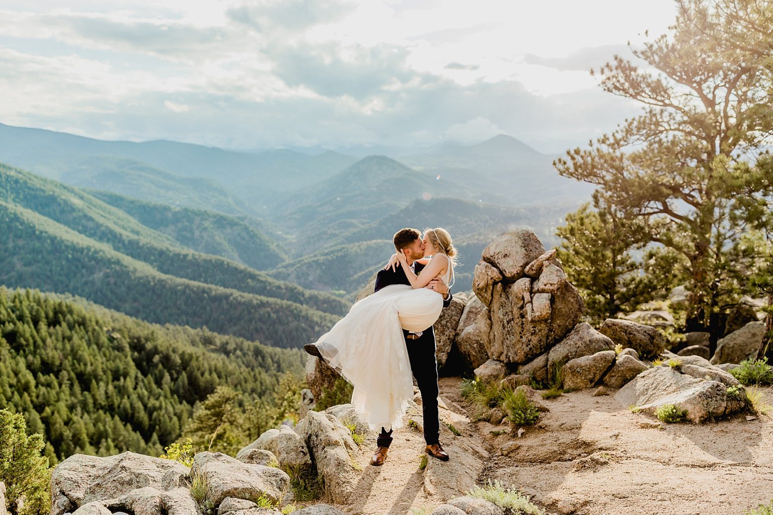 groom picks up bride with stunning Rocky Mountain colorado background