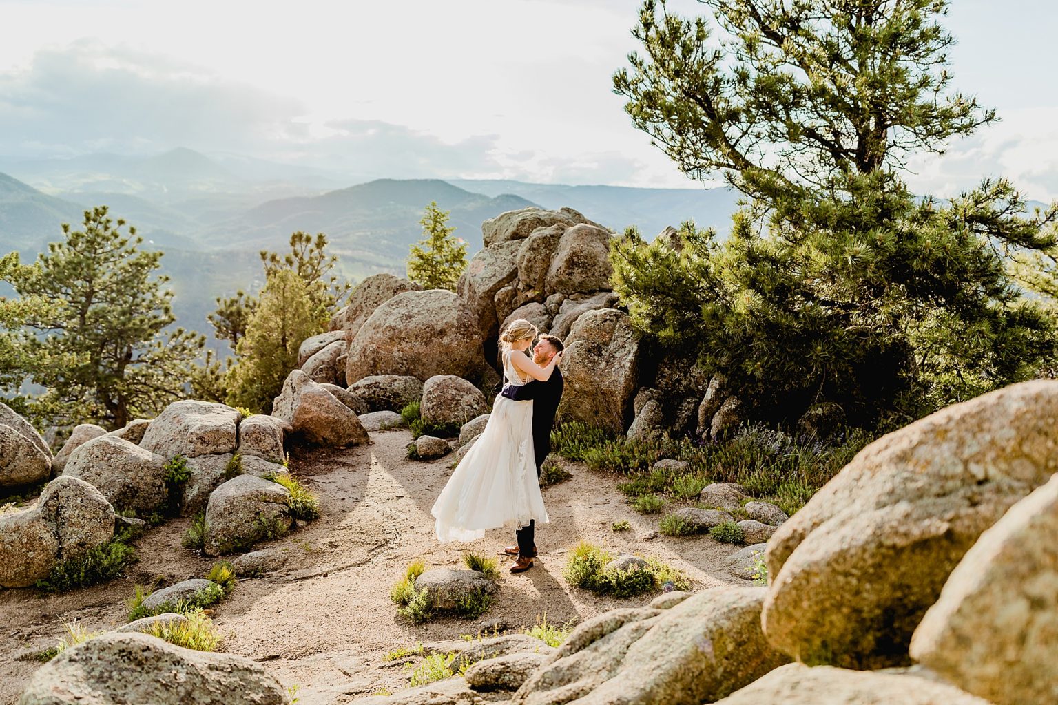 groom spins bride around with beautiful Rocky Mountain colorado background