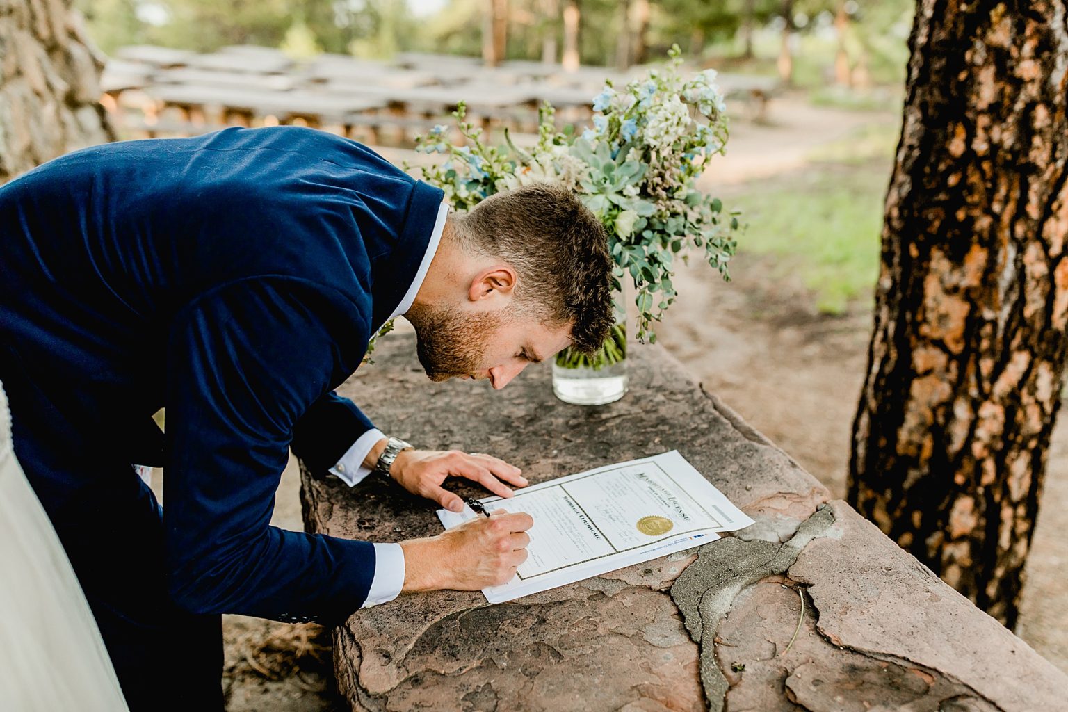 groom signs the marriage certificate outside