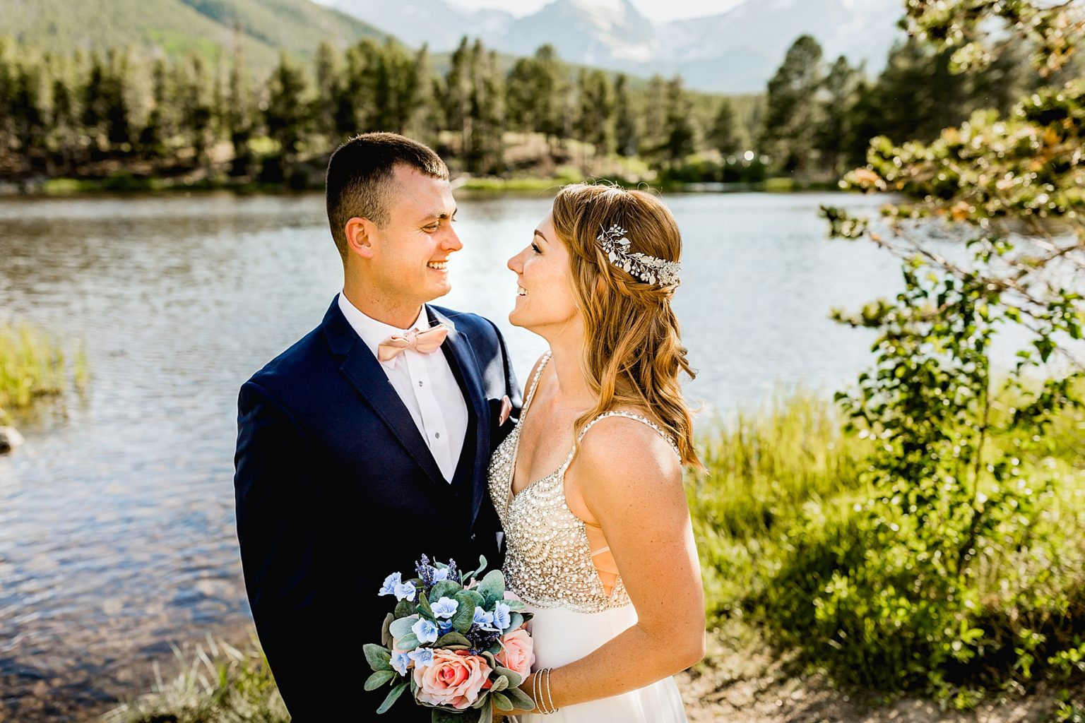bride and groom share first look together next to beautiful trees and lake
