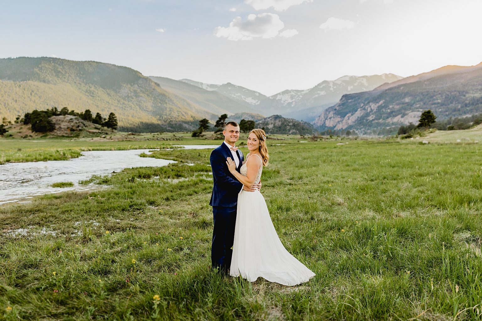 bride and groom embrace in beautiful Estes Park at sunset after their elopement in moraine park