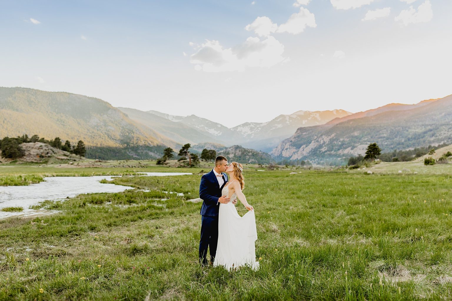bride and groom embrace in beautiful Estes Park at sunset after their elopement in moraine park