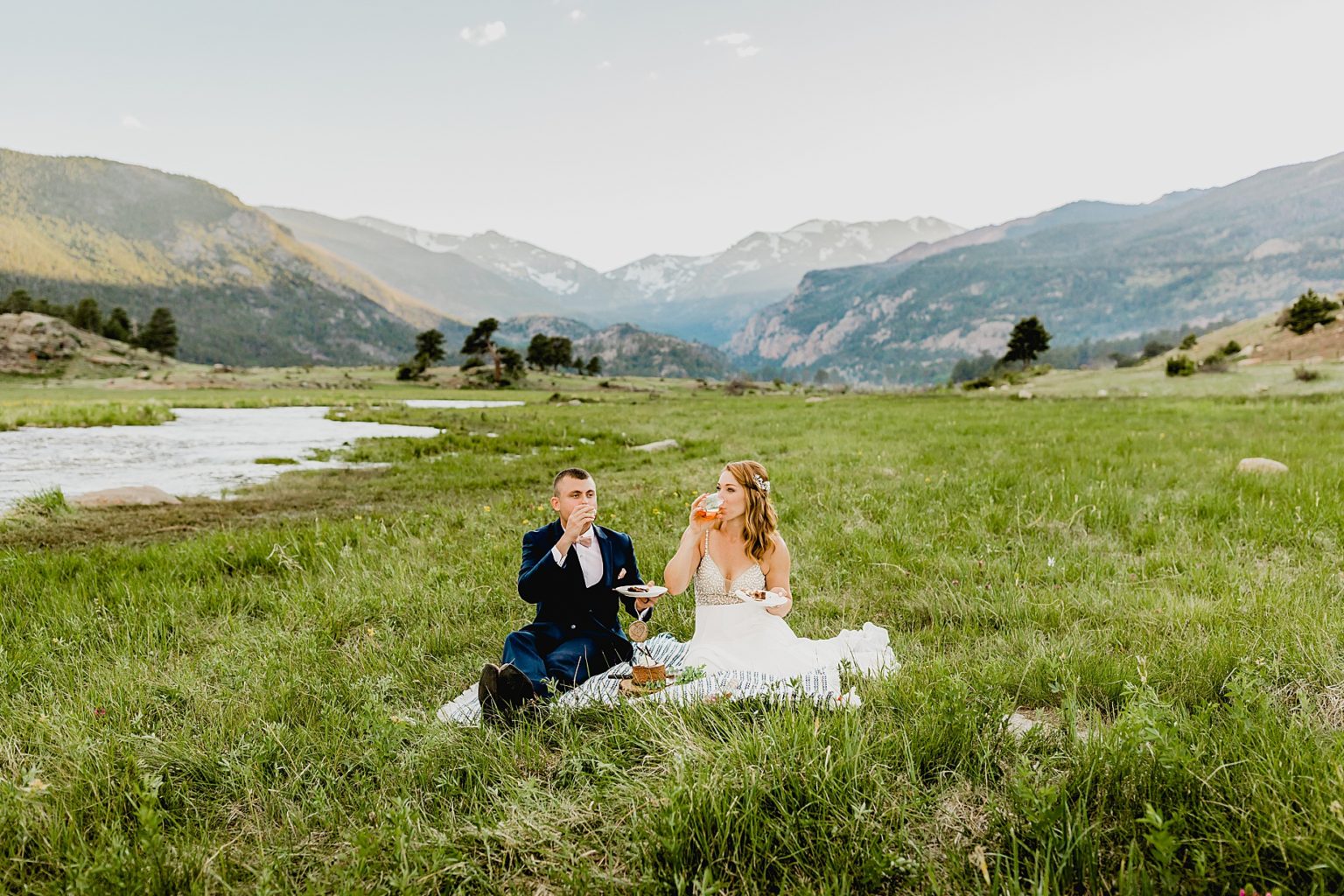 bride and groom share drinks with mountain backdrop