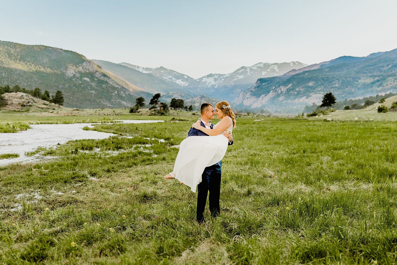 groom holds his bride in gorgeous colorado mountain scenery