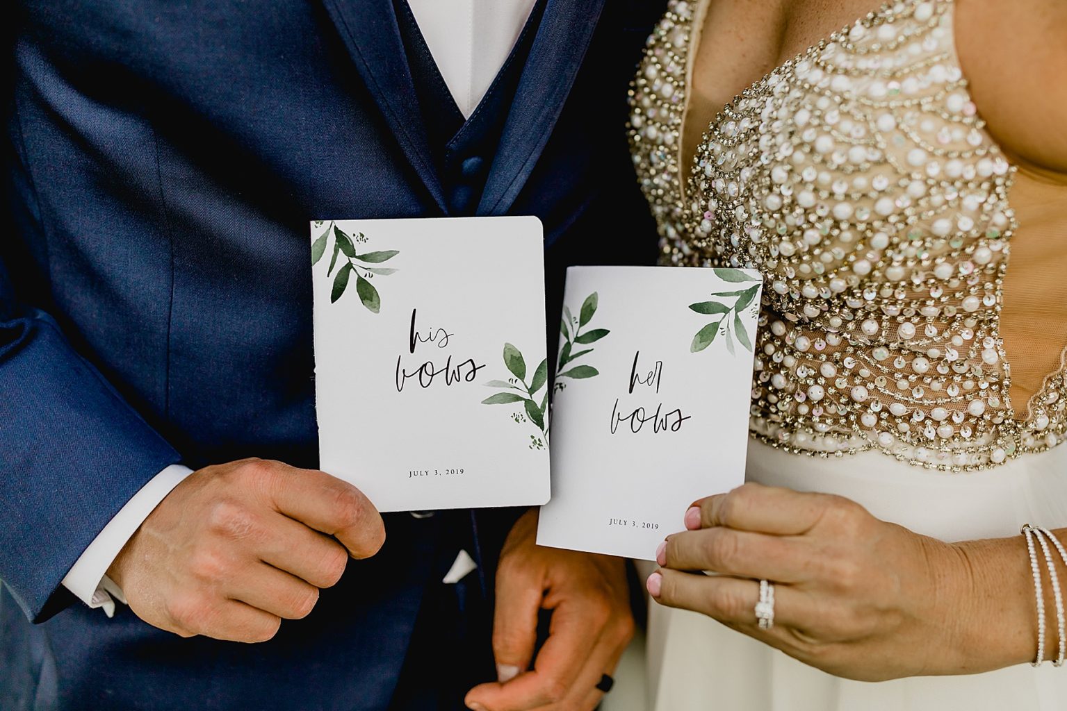 bride and groom hold up vow books