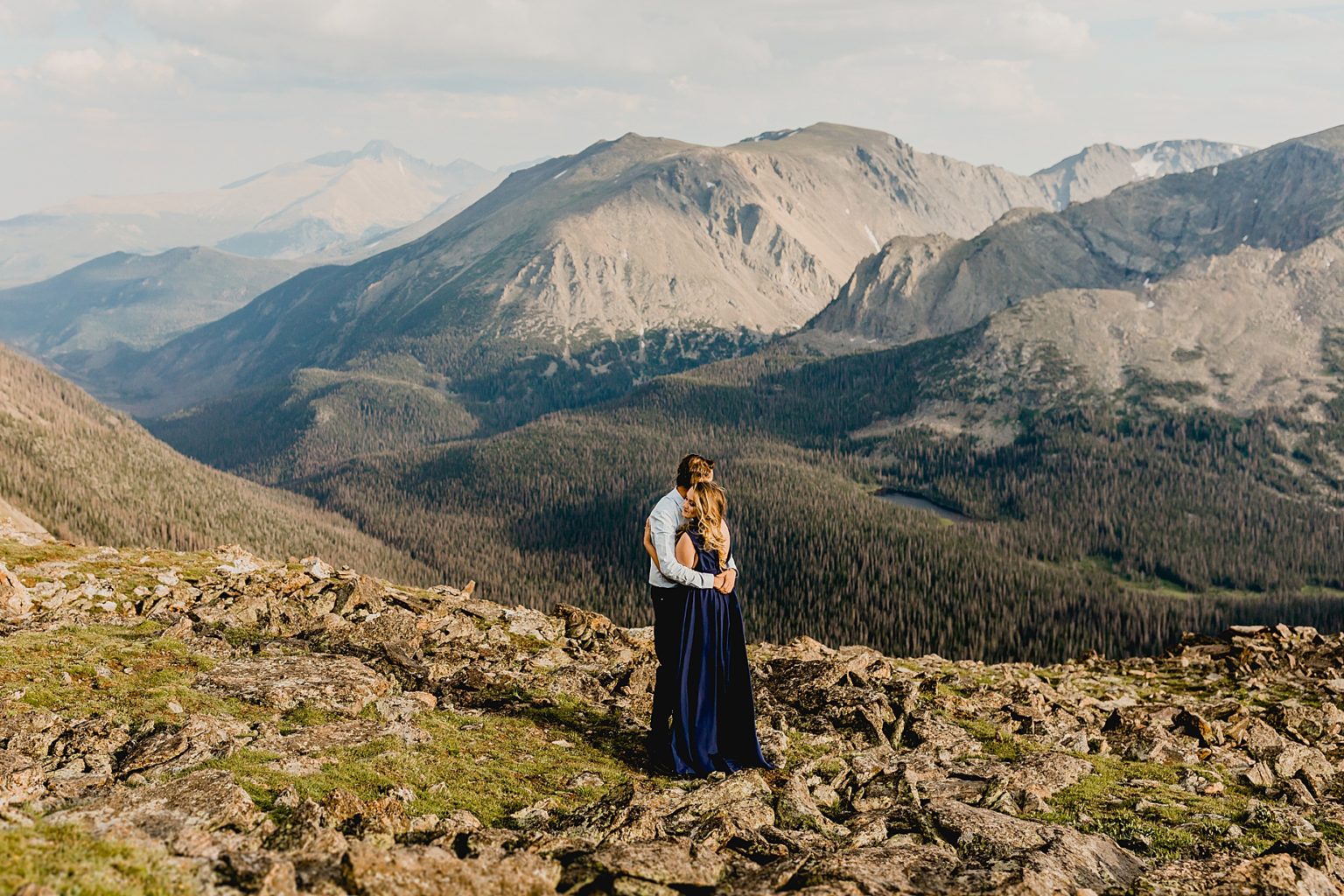 couple hugging in wildflowers with gorgeous mountain background