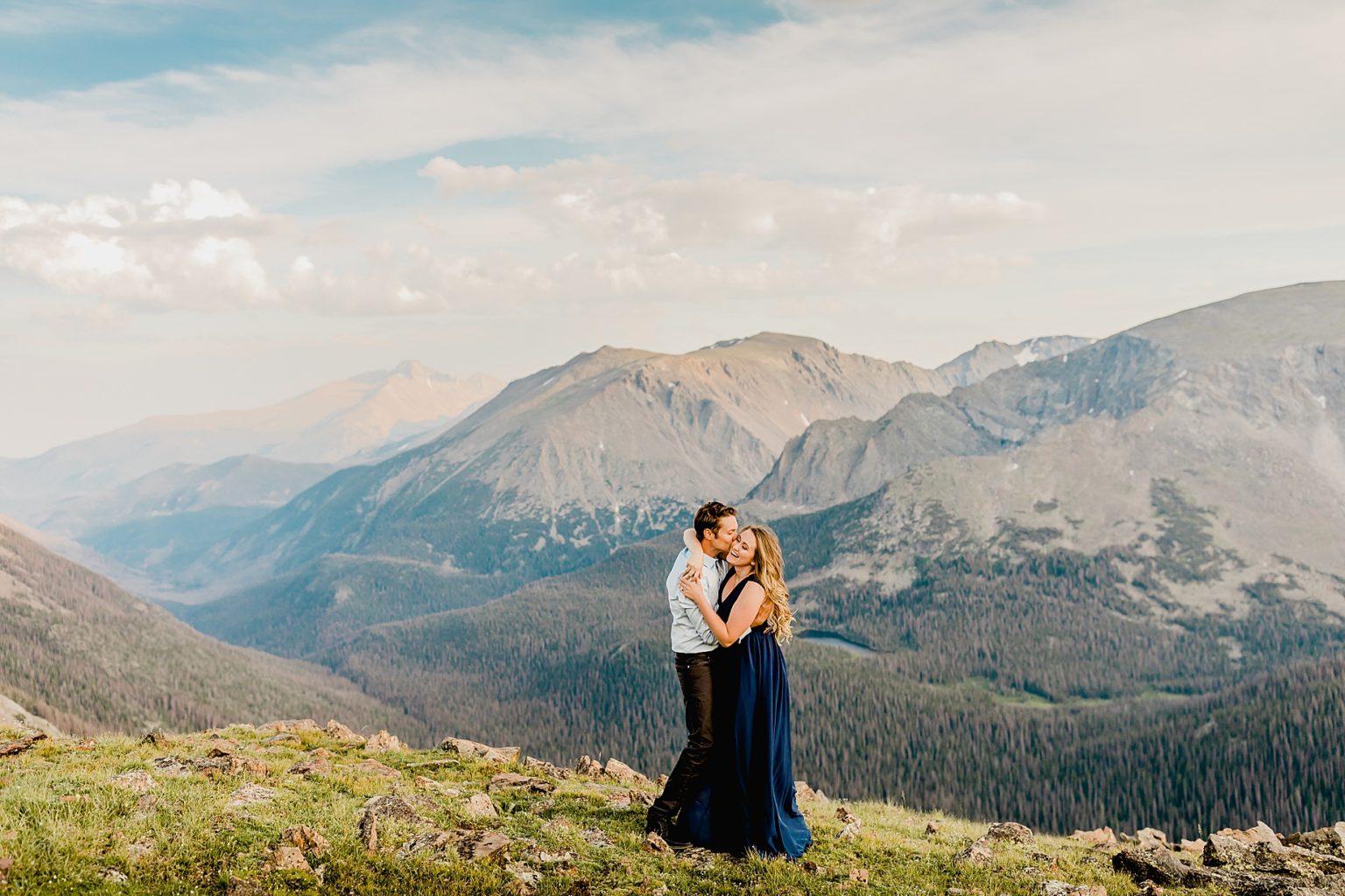 couple laughing together at sunset with gorgeous Rocky Mountain scenery showing the amazing pink and blue sunset colors