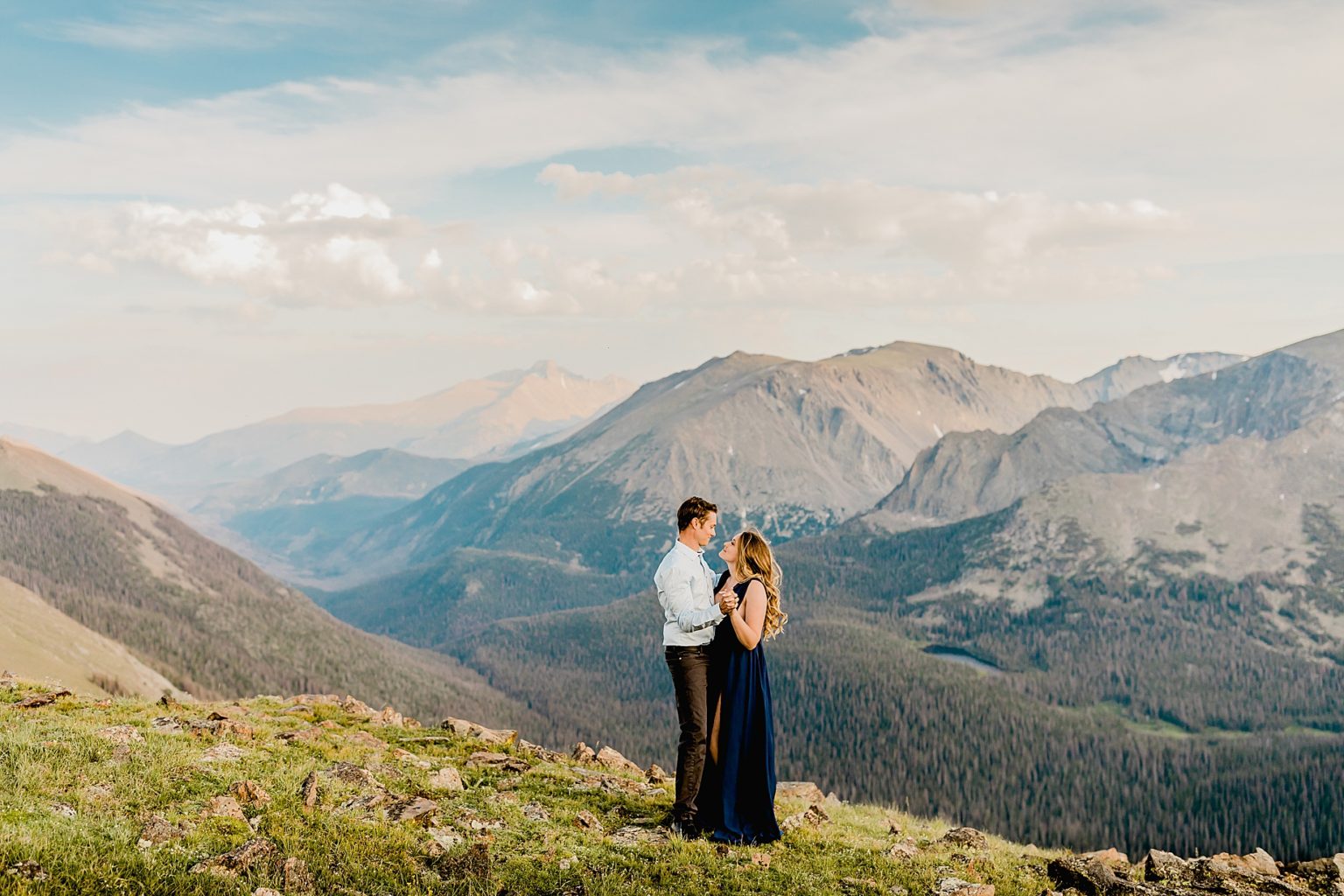 couple embraces together with stunning colorado mountain scenery in the background