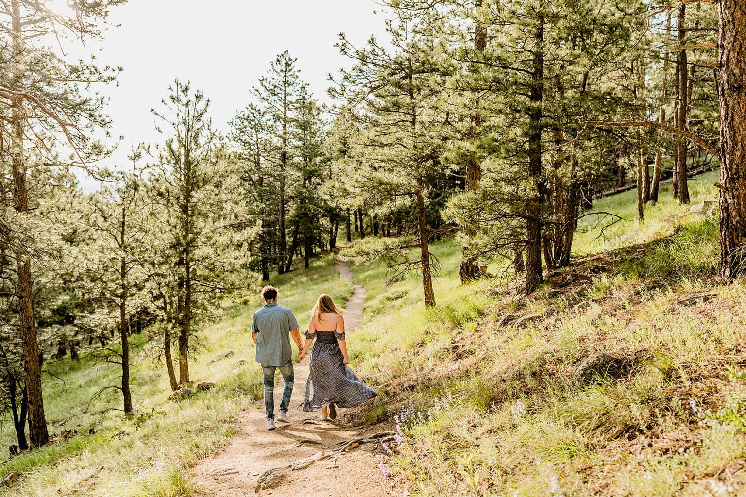 couple walking on a trail through the vibrant colorado trees