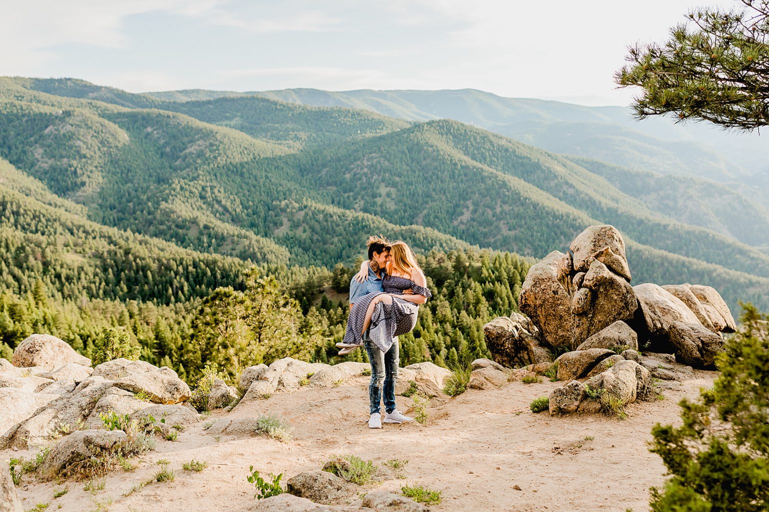 man lifts woman up and holds her in the stunning colorado mountain scenery