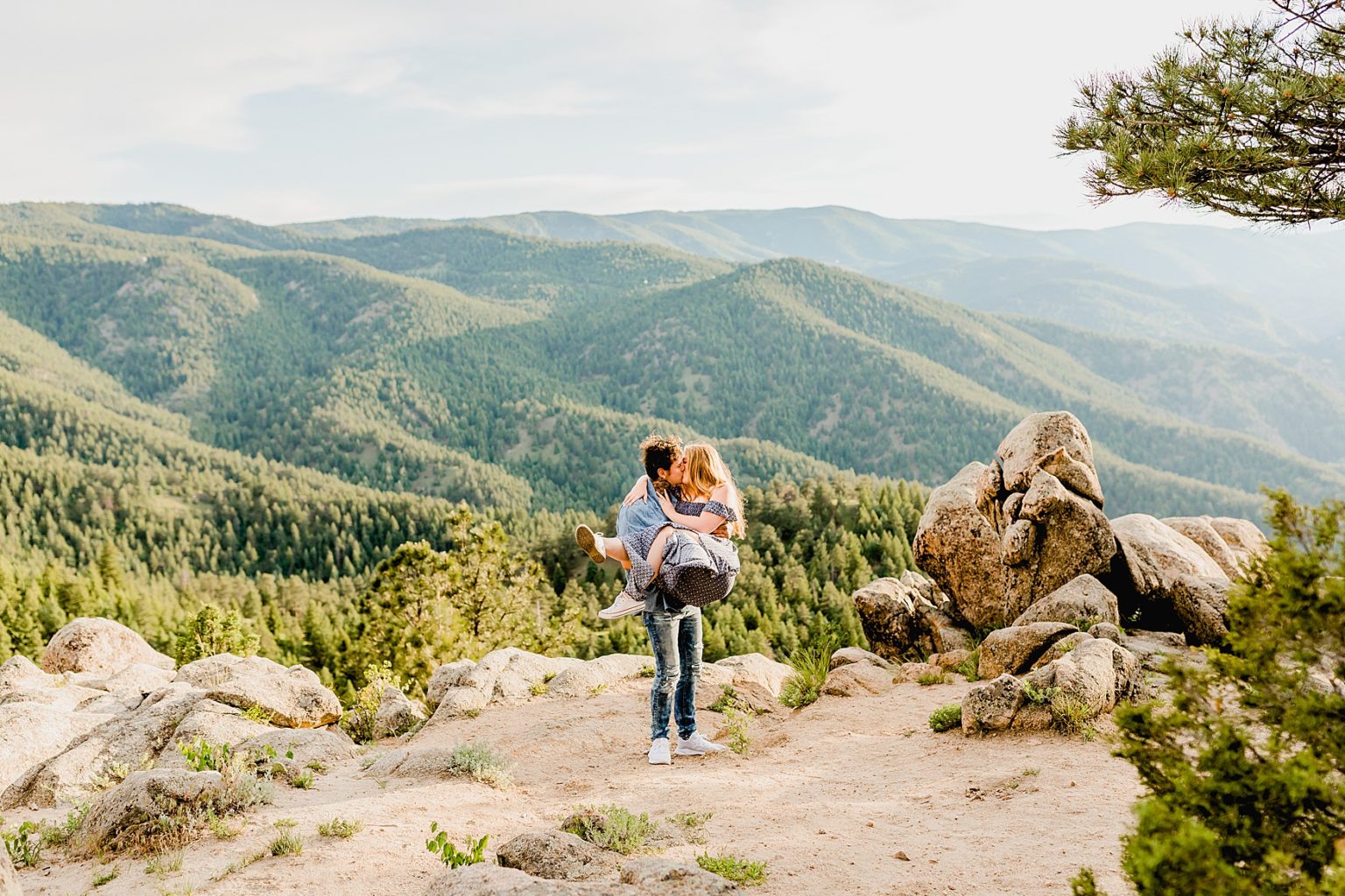 man lifts woman up and holds her in the stunning colorado mountain scenery