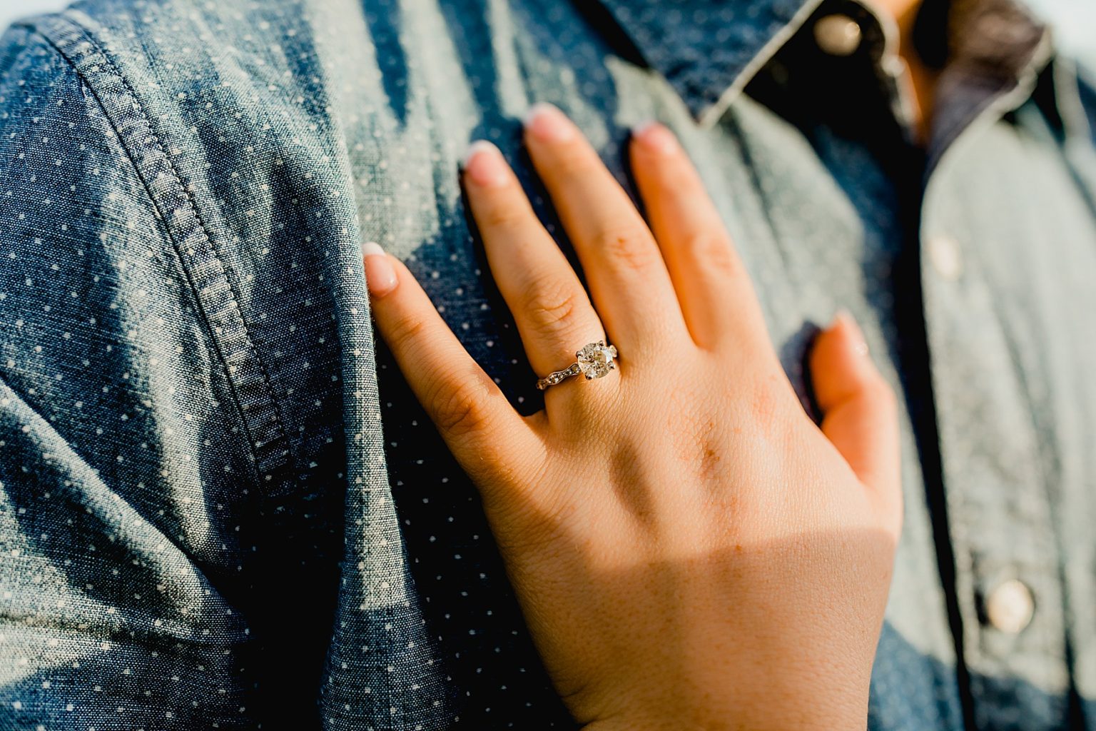engagement ring shot with womans hand on mans chest