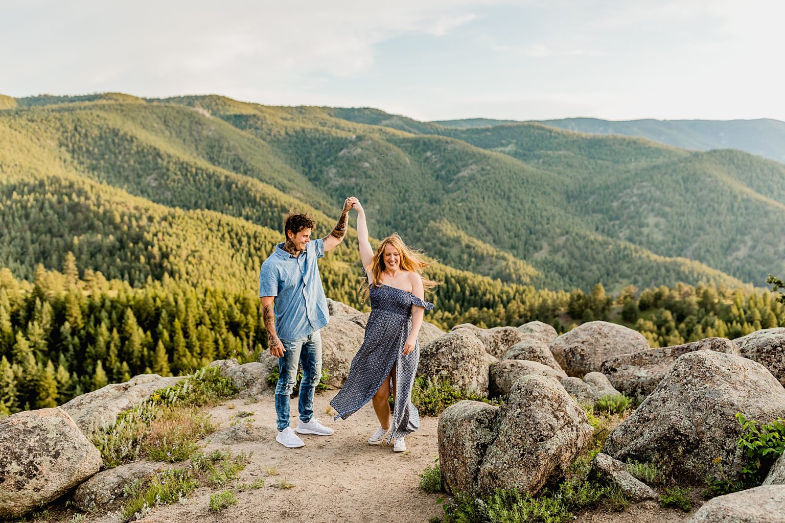 couple dances together surrounded by rocks and gorgeous green mountain scenery