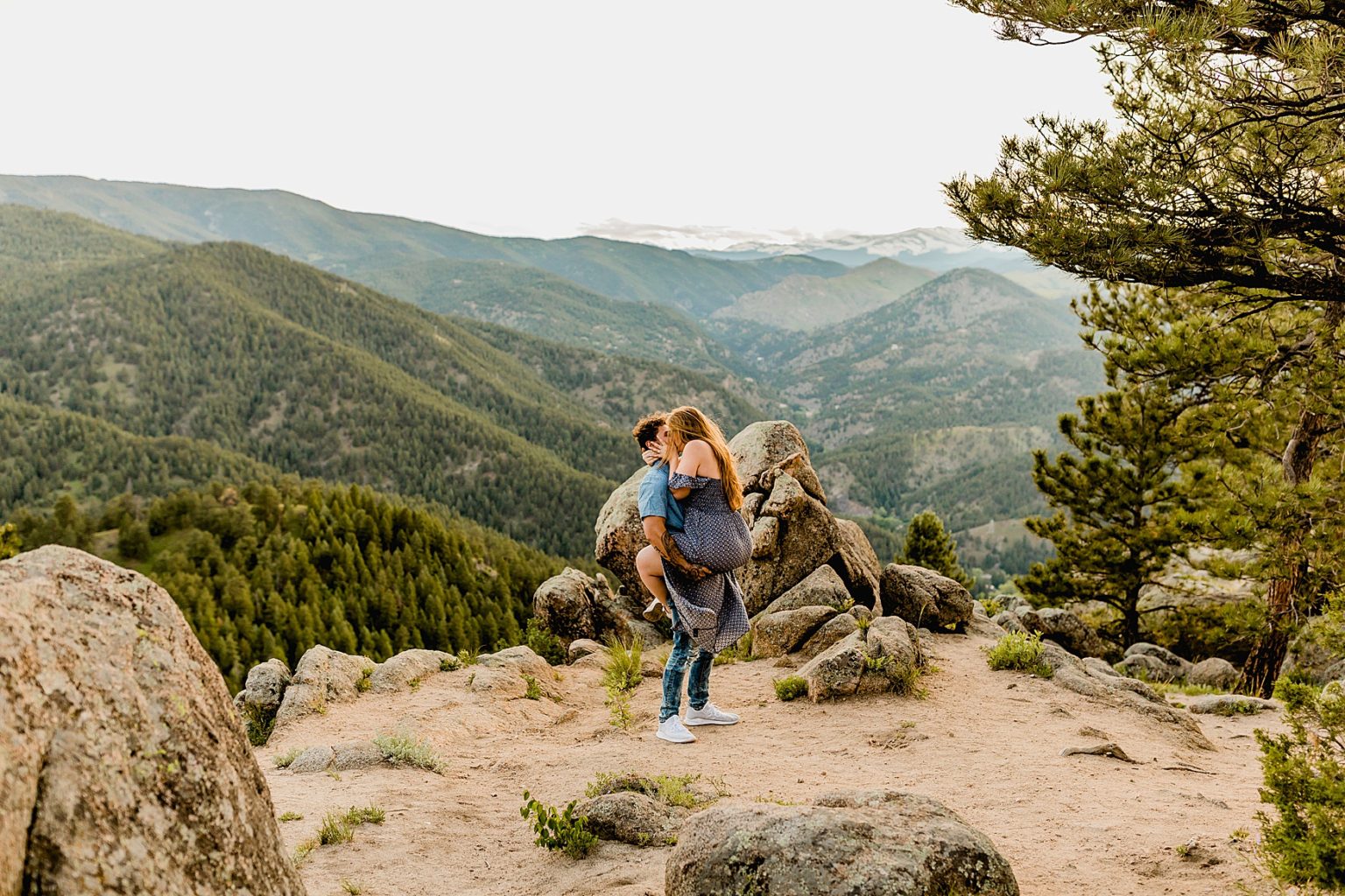 woman jumps into mans arms for a kiss with incredible mountain backdrop