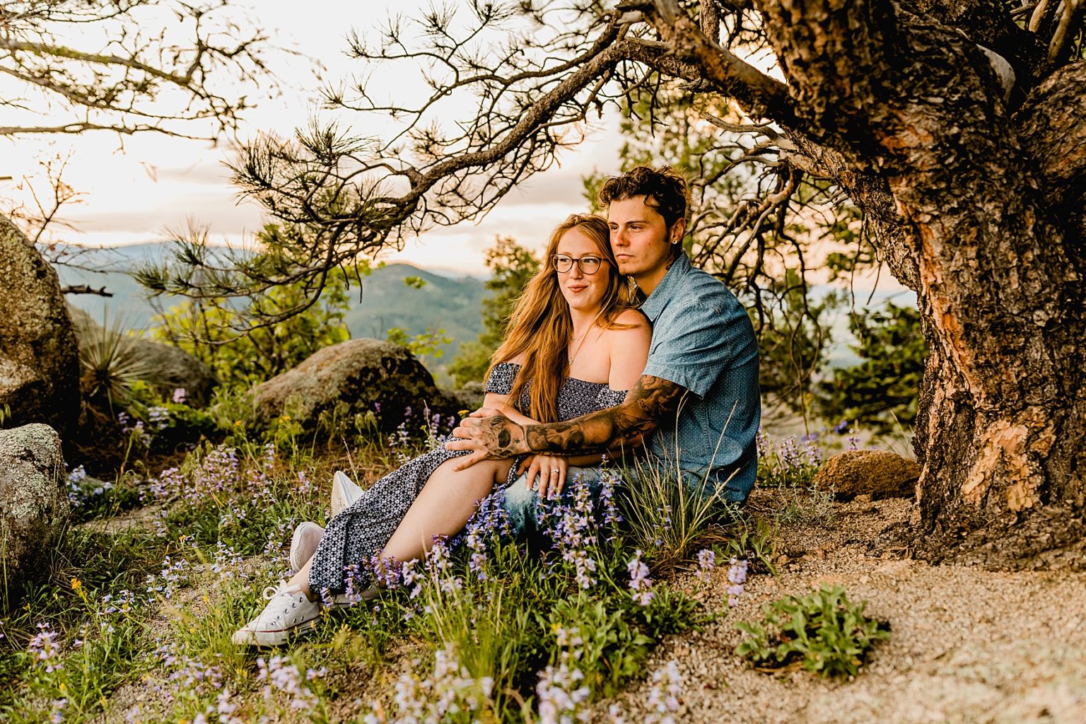 couple sits together in colorado wildflowers