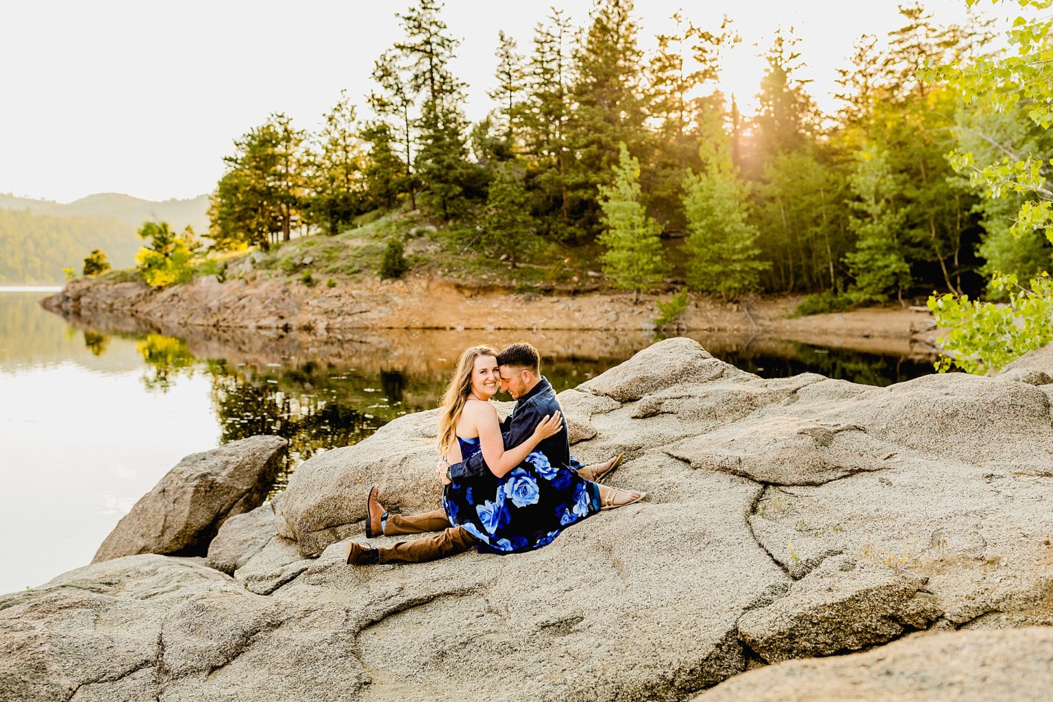 evergreen trees and lake background with couple celebrating anniversary in boulder colorado