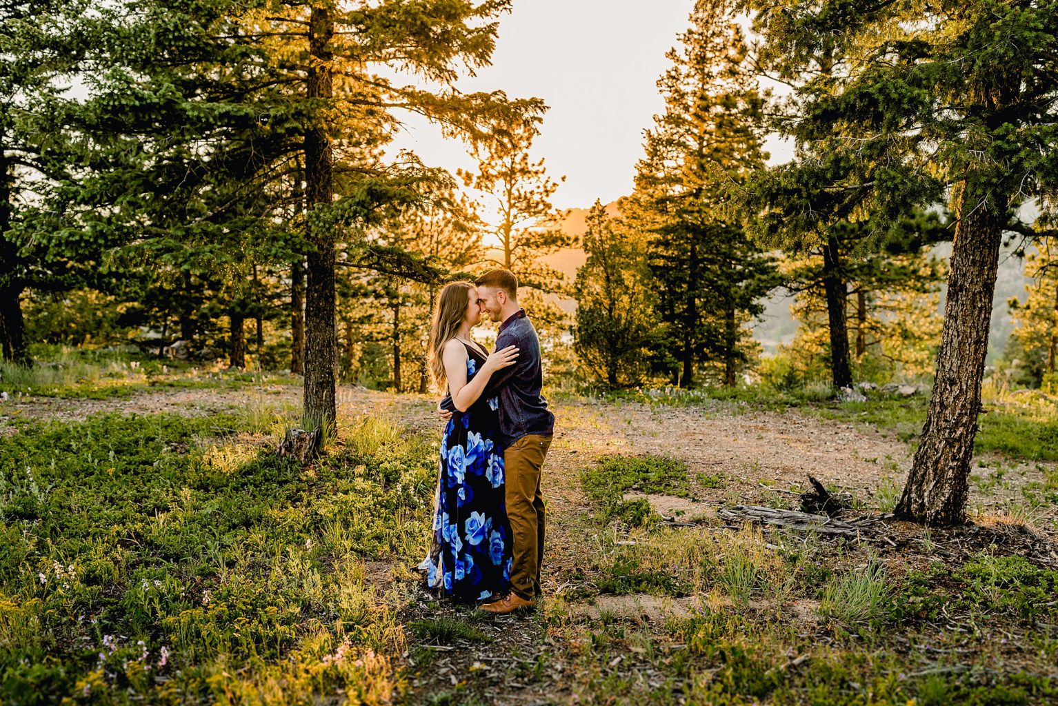 couple holds each other during sunset in beautiful boulder colorado location with stunning scenery around them