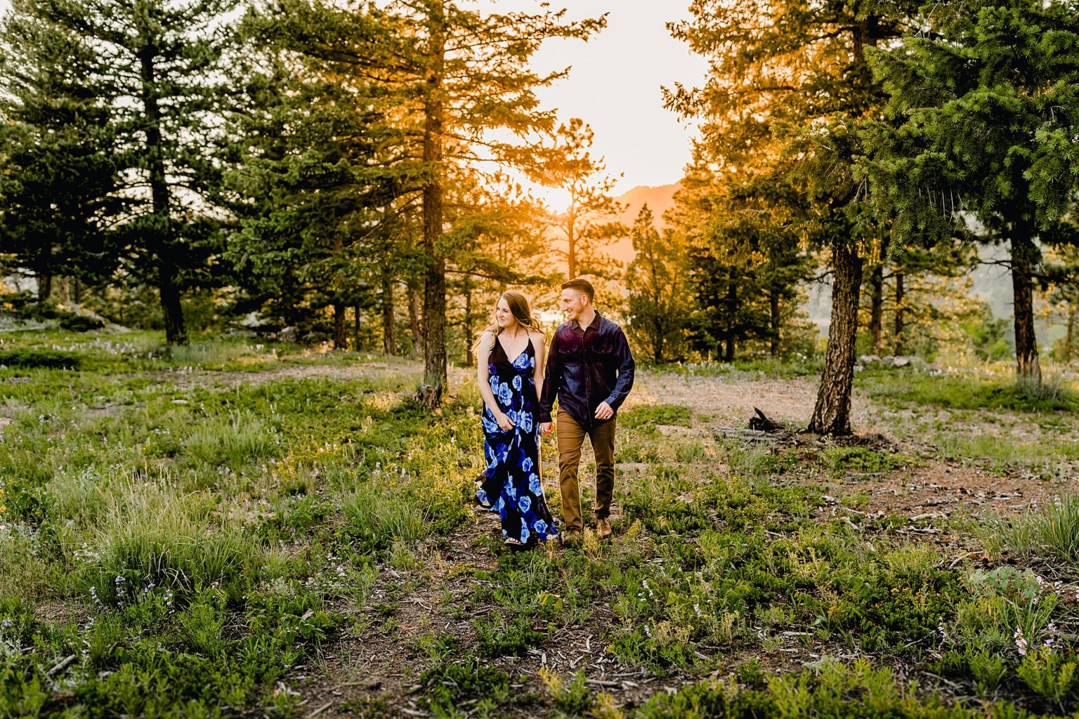 couple holds each other during sunset in beautiful boulder colorado location with stunning scenery around them