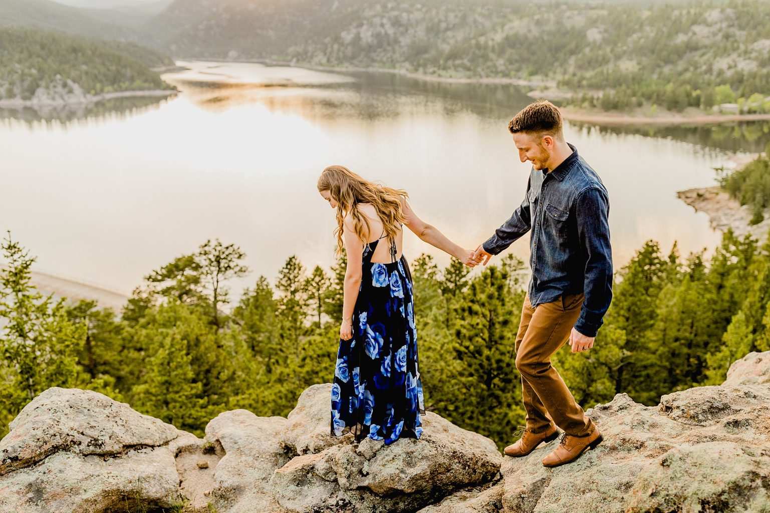couple stands together overlooking incredible rocky mountain scenery and lake to celebrate anniversary