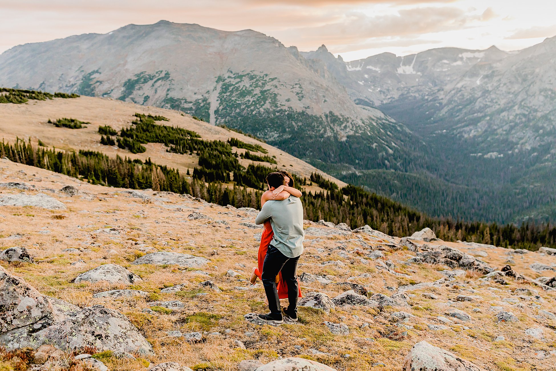 couple embraces after rocky mountain national park proposal, couple is filled with joy among incredible colorado mountain landscape
