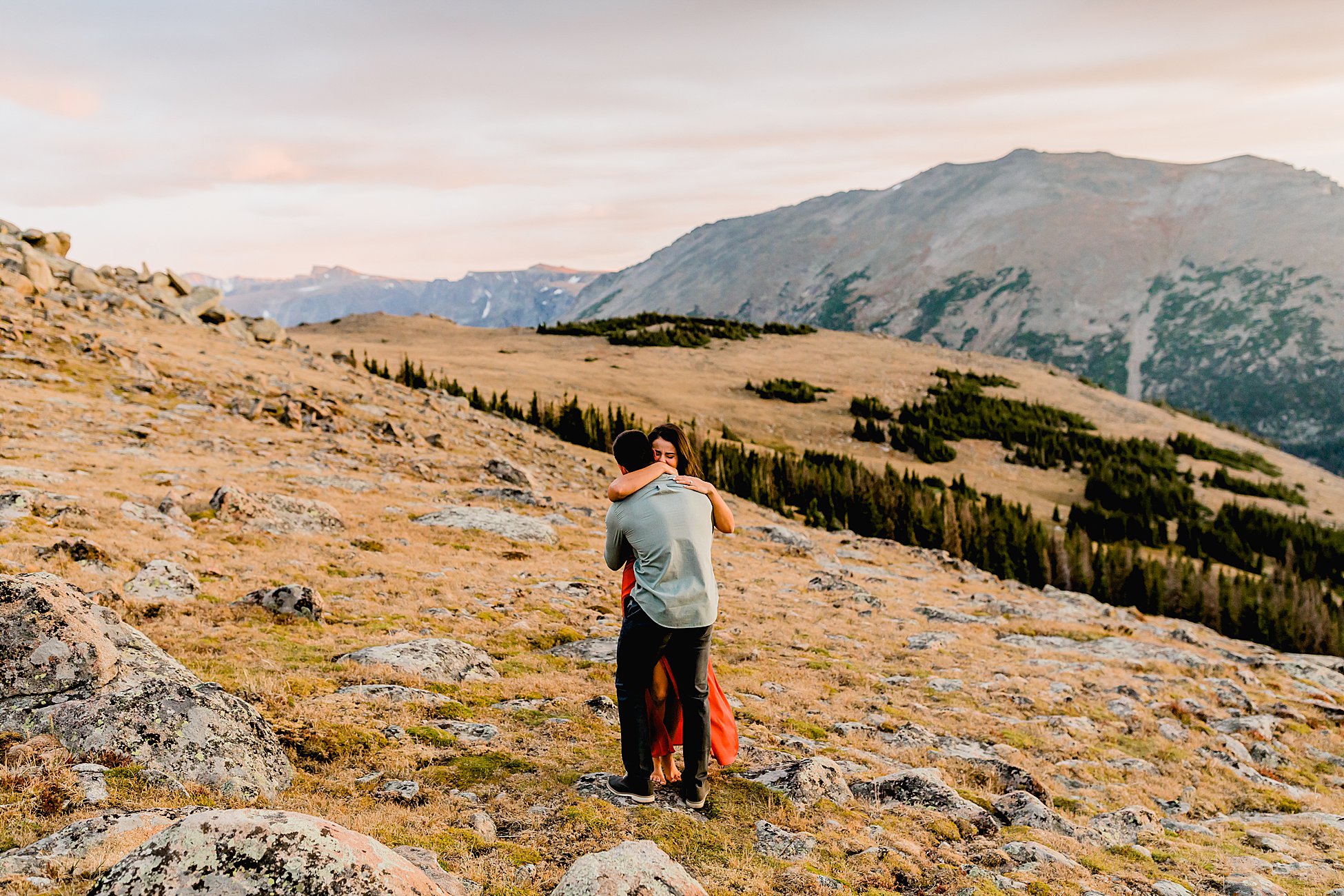 couple embraces after rocky mountain national park proposal, couple is filled with joy among incredible colorado mountain landscape